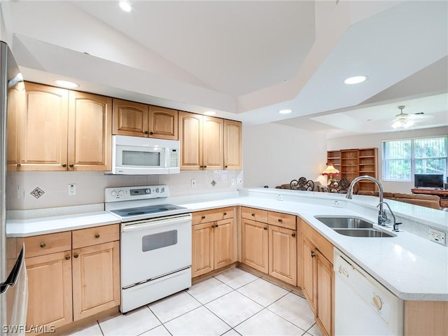 kitchen with kitchen peninsula, white appliances, ceiling fan, sink, and lofted ceiling