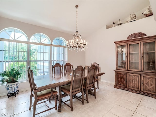 dining space with a notable chandelier, light tile patterned floors, and vaulted ceiling