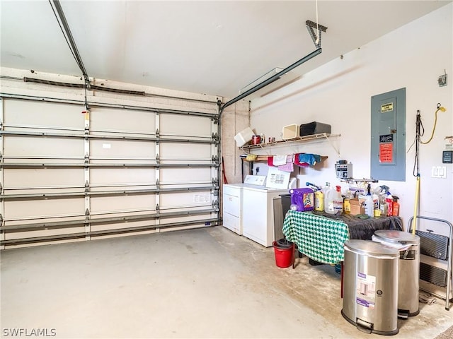 garage featuring electric panel and washing machine and clothes dryer