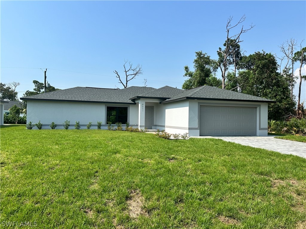 view of front of property with a garage and a front lawn