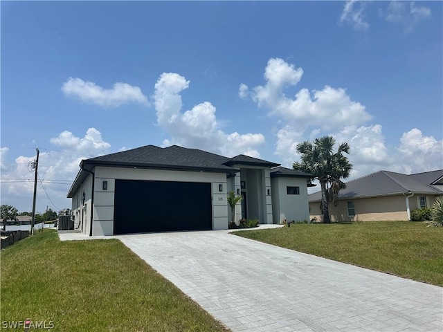 view of front of house with a front yard, a garage, and central AC unit