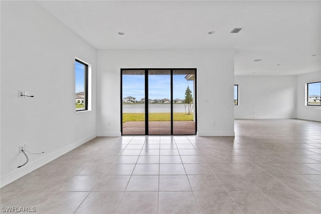 tiled empty room with a healthy amount of sunlight