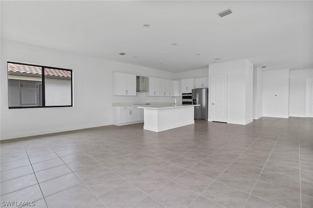 unfurnished living room with sink and light tile patterned floors