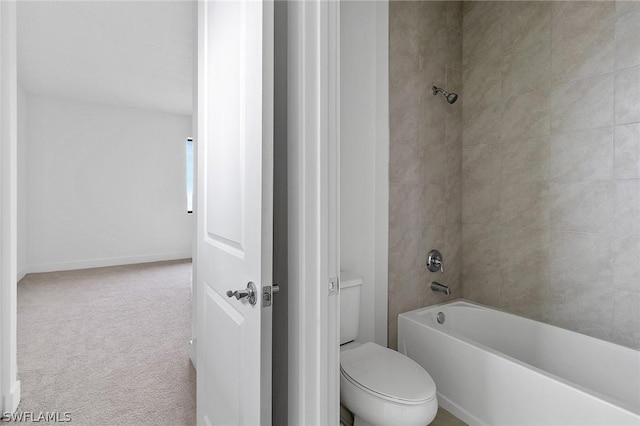 bathroom featuring tiled shower / bath and toilet