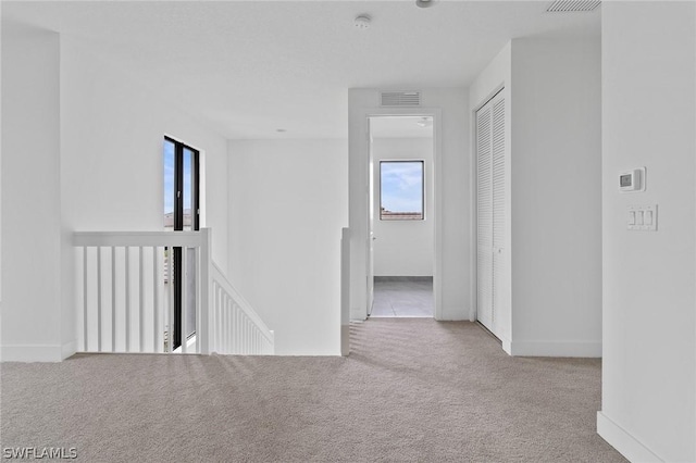 hallway featuring light colored carpet