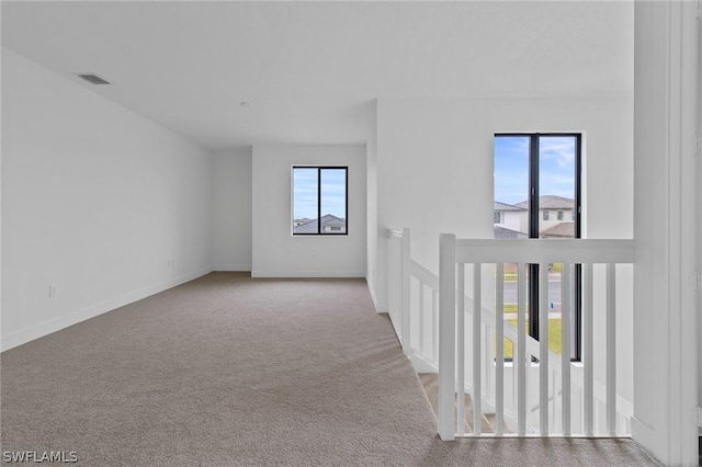 carpeted empty room featuring plenty of natural light