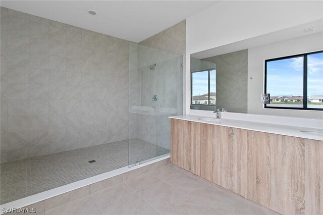 bathroom featuring tile patterned floors, vanity, and a tile shower