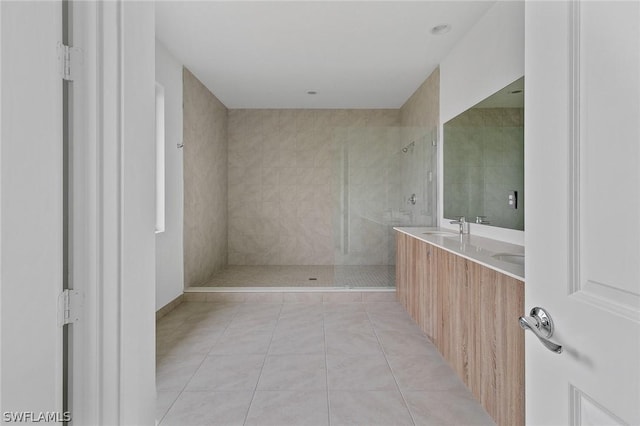 bathroom with vanity, tile patterned flooring, and a tile shower