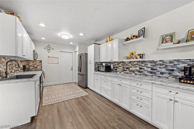 kitchen with dark hardwood / wood-style flooring, tasteful backsplash, white cabinetry, appliances with stainless steel finishes, and sink