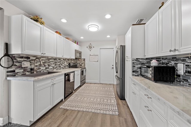 kitchen featuring appliances with stainless steel finishes, tasteful backsplash, and hardwood / wood-style floors