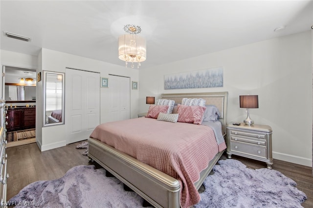 bedroom with an inviting chandelier and hardwood / wood-style floors