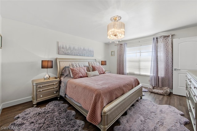 bedroom with a notable chandelier and dark wood-type flooring