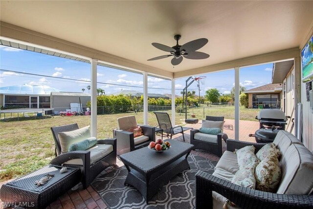 sunroom featuring a healthy amount of sunlight and ceiling fan