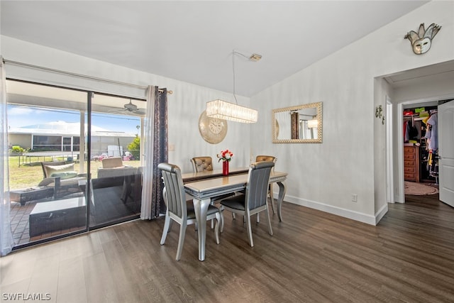 dining room with dark wood-type flooring and vaulted ceiling