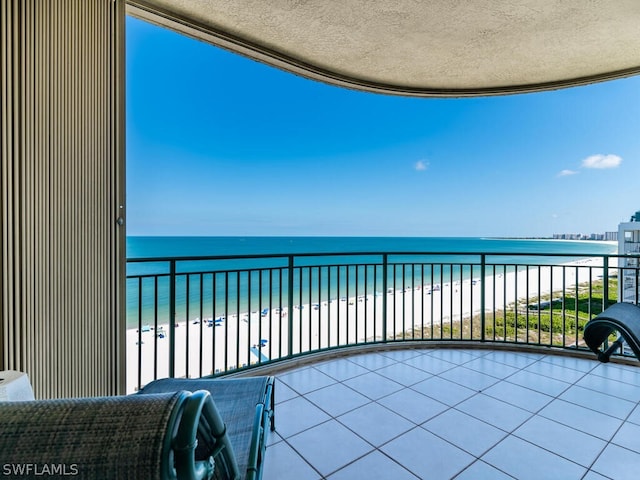 balcony with a water view and a beach view