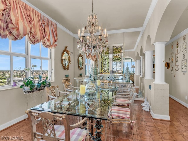 dining area with a notable chandelier, ornamental molding, and decorative columns