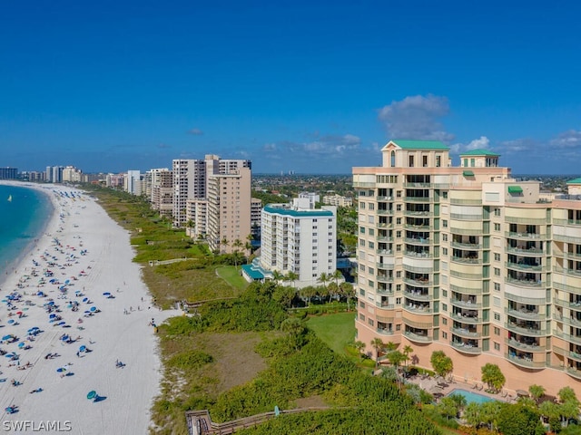 birds eye view of property with a water view and a beach view