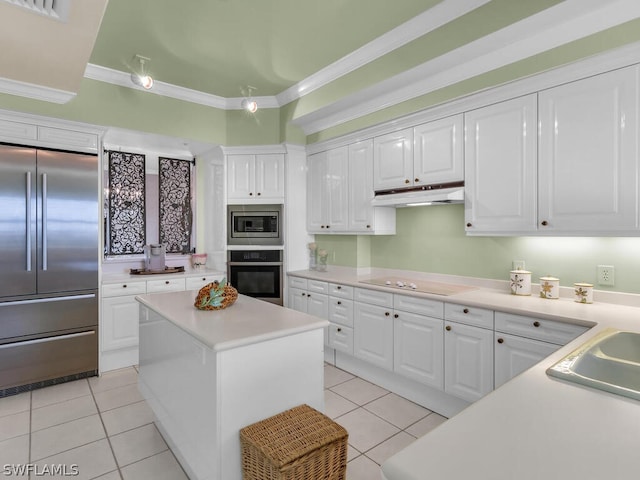 kitchen with crown molding, built in appliances, light tile patterned floors, a kitchen island, and white cabinetry