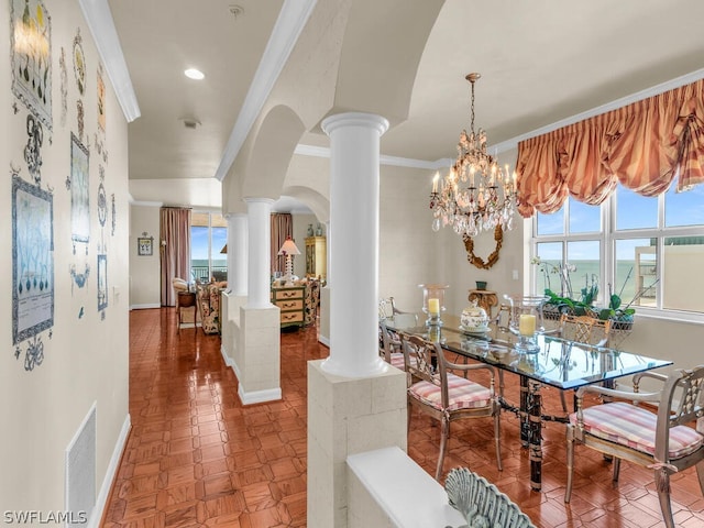 dining space featuring a chandelier, ornamental molding, ornate columns, and a healthy amount of sunlight