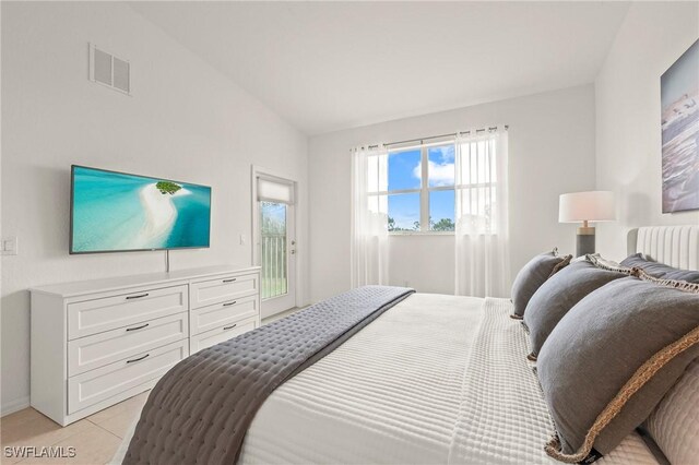 tiled bedroom featuring vaulted ceiling and access to exterior