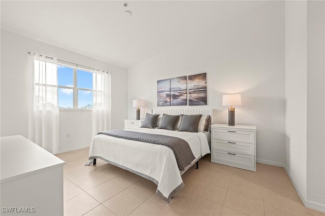 bedroom with light tile patterned floors and baseboards
