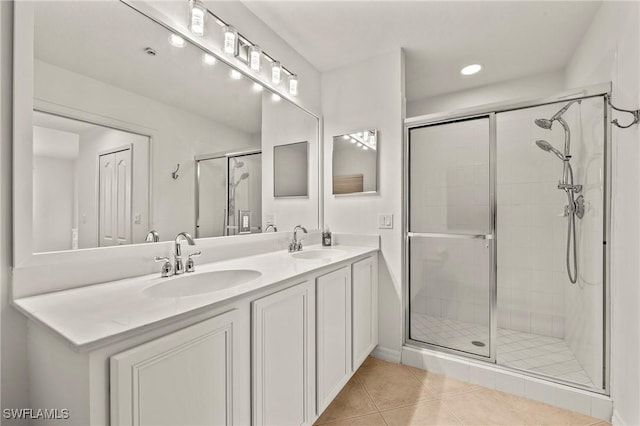 bathroom featuring tile patterned floors, a shower with door, and vanity