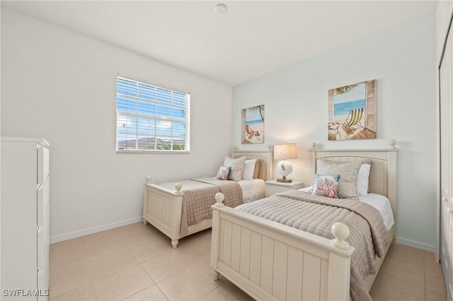 bedroom with light tile patterned floors and baseboards