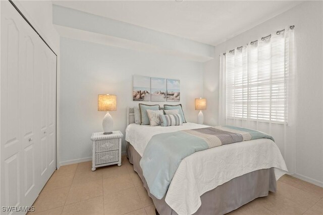 bedroom with a closet and light tile patterned flooring