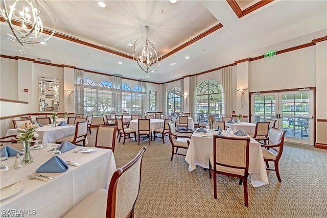 dining space with ornamental molding, light colored carpet, a tray ceiling, an inviting chandelier, and french doors