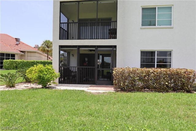 back of property featuring a lawn and a balcony