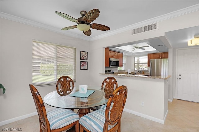 tiled dining space featuring ceiling fan, ornamental molding, and sink