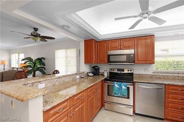 kitchen with kitchen peninsula, light stone counters, ornamental molding, and appliances with stainless steel finishes