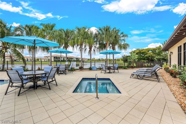 view of pool with a patio and a water view