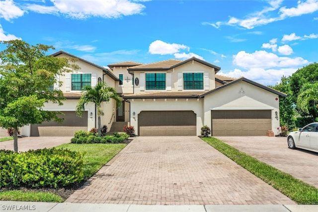 2375 Montserrat Ln Unit 202, Naples, FL 34120 - view of front of home with stucco siding, an attached garage, and decorative driveway
