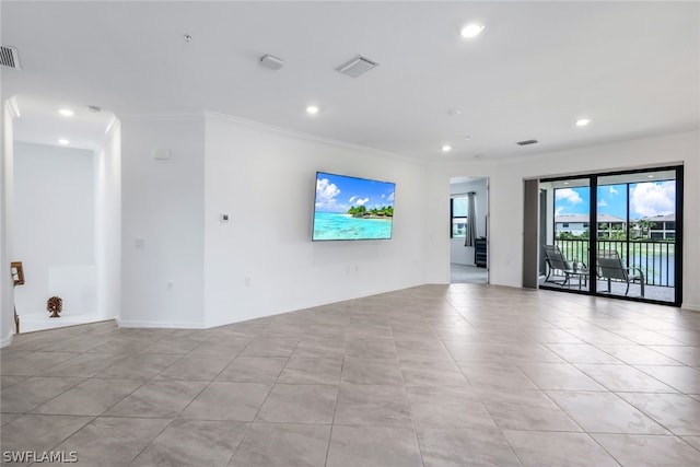 unfurnished room with ornamental molding and light tile patterned floors