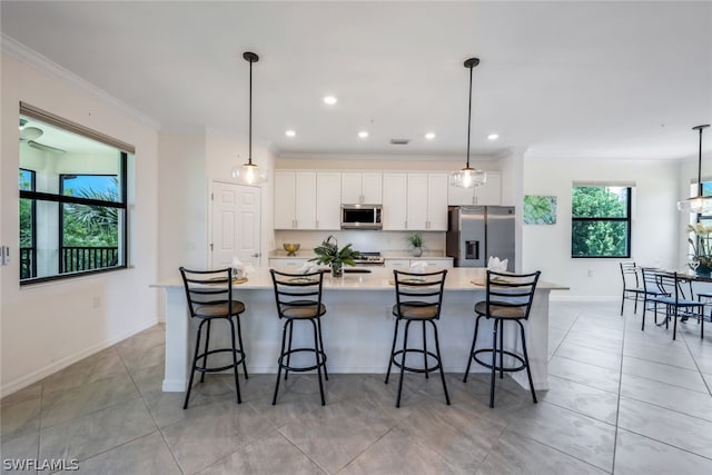 kitchen with a spacious island, hanging light fixtures, and appliances with stainless steel finishes