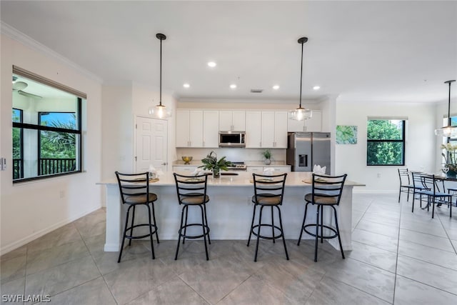 2375 Montserrat Ln Unit 202, Naples, FL 34120 - kitchen featuring white cabinets, appliances with stainless steel finishes, light countertops, a large island with sink, and ornamental molding
