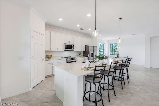 2375 Montserrat Ln Unit 202, Naples, FL 34120 - kitchen with a breakfast bar, a large island, white cabinets, a sink, and stainless steel appliances