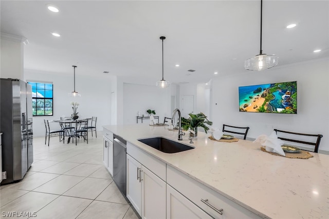 2375 Montserrat Ln Unit 202, Naples, FL 34120 - kitchen featuring light stone countertops, white cabinets, a sink, appliances with stainless steel finishes, and decorative light fixtures