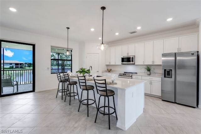 kitchen with pendant lighting, an island with sink, appliances with stainless steel finishes, white cabinetry, and a breakfast bar area