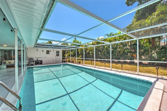 view of swimming pool with glass enclosure and a patio