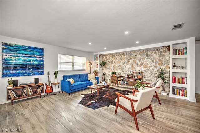 living room with built in features and light hardwood / wood-style flooring