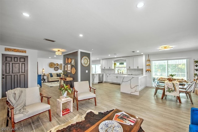 living room with sink and light hardwood / wood-style flooring