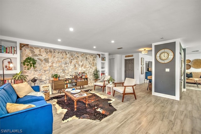 living room featuring built in features and light wood-type flooring