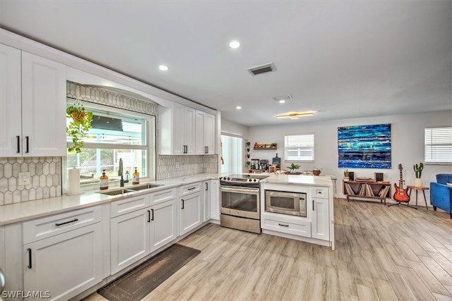 kitchen featuring white cabinets, light hardwood / wood-style floors, sink, and appliances with stainless steel finishes