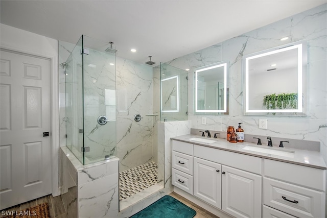 bathroom with a tile shower, vanity, and hardwood / wood-style flooring