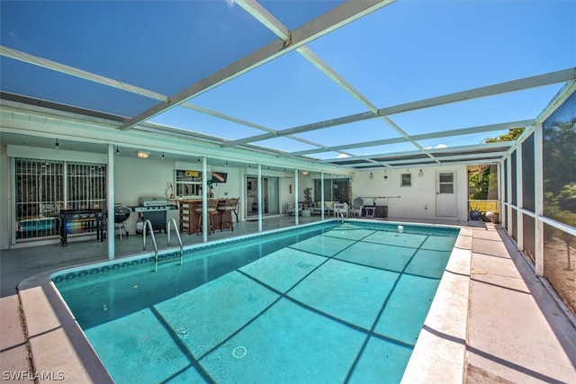 view of swimming pool featuring glass enclosure and a patio