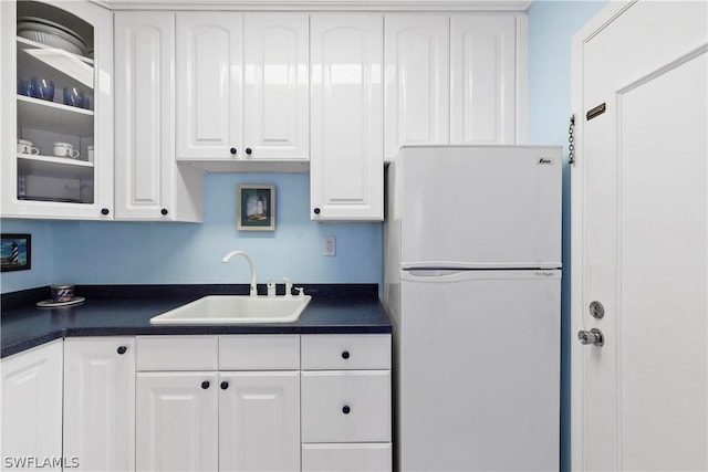 kitchen with white cabinets, white fridge, and sink