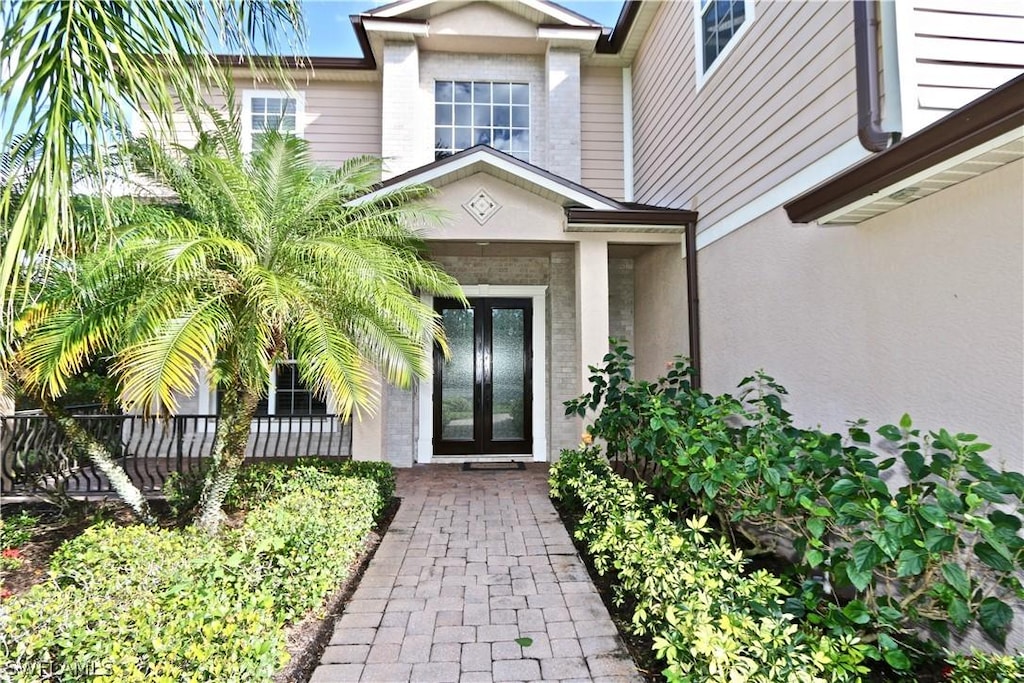 entrance to property featuring french doors and stucco siding