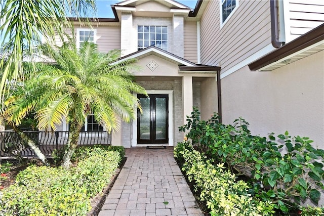 entrance to property featuring french doors and stucco siding